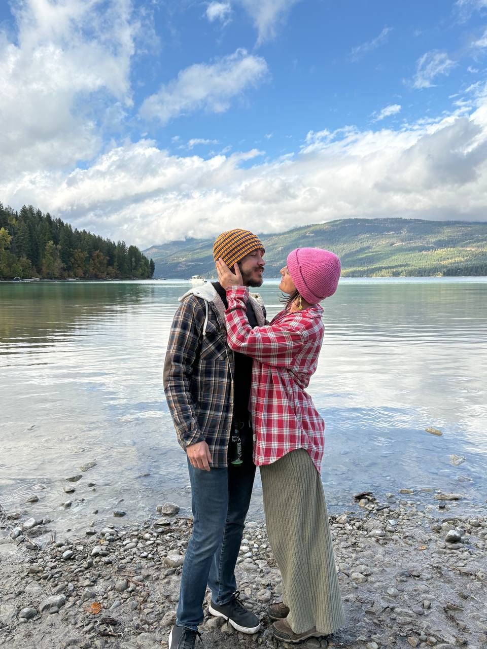 Therese holding Thomas's face by the lake